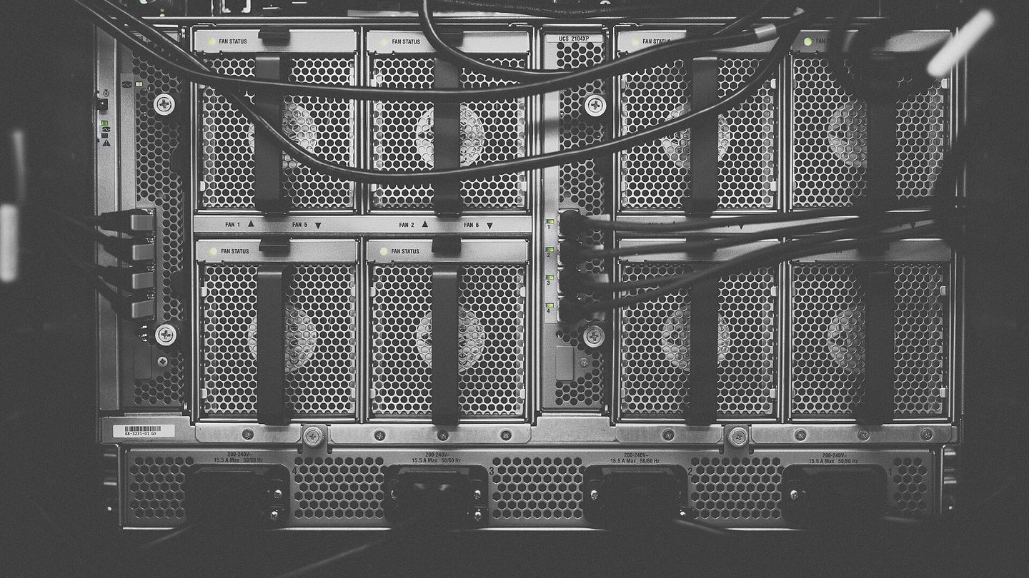 Rückseite eines Server-Racks mit Lüftern, Netzteilen und verlegten Kabeln in Schwarz-Weiß